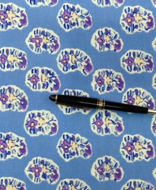 Tela de Patchwork con tres flores recortadas sobre fondo azul azafata con bolígrafo como referencia - Conchi Berguño