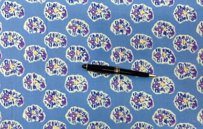 Tela de Patchwork con tres flores recortadas sobre fondo azul azafata con bolígrafo como referencia - Conchi Berguño