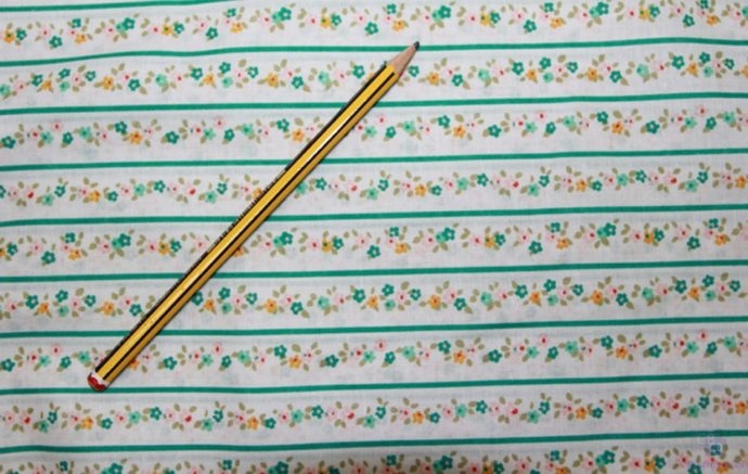 Tela de Patchwork con guirnalda de florecillas a tres colores separadas por raya verde con lápiz como referencia - Conchi Berguño