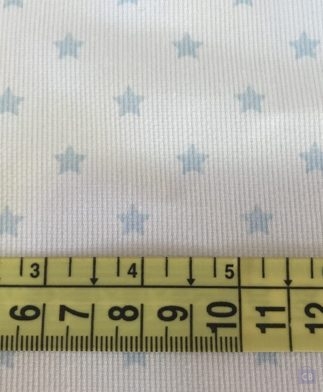 Tela Piqué de Canutillo Blanco con Estrellitas Azul Clarito - Detalle de la cinta métrica como referencia - Conchi Berguño