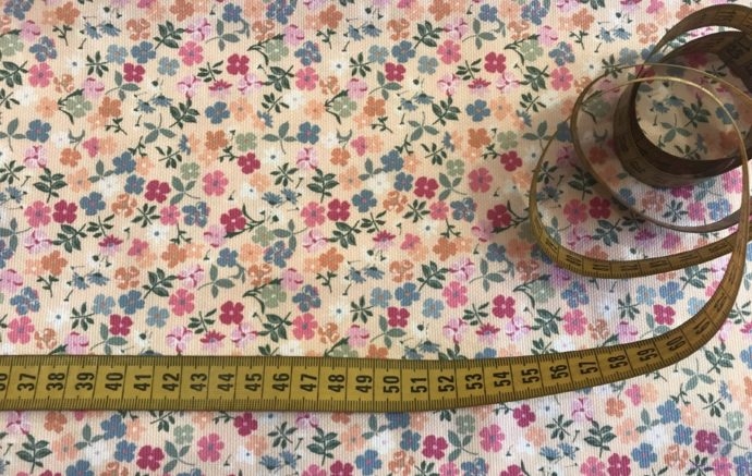 Tela Piqué de Canutillo de Flores Multicolor en Fondo Crema - Detalle de la cinta métrica como referencia - Conchi Berguño