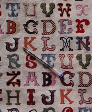 Tela tipo cretona con dibujos de letras multicolor