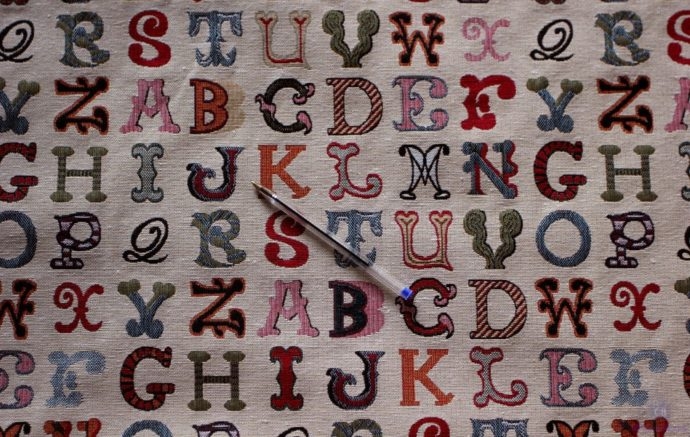 Tela tipo cretona con dibujos de letras multicolor