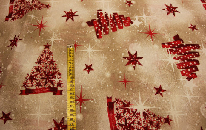 Tela Loneta de Navidad con Estrellas y Abetos Rojos , Fondo Beige Jaspeado . Ancho 2.80 metros. Detalle cinta-Conchi Berguño.